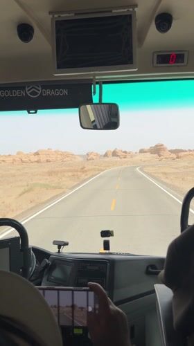 Bus travels desert road near Dunhuang City, China