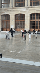 Young adults rehearse dance routine in Paris courtyard