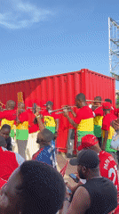 Accra crowd gathers for outdoor sports viewing with Arsenal jerseys