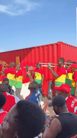 Accra crowd gathers for outdoor sports viewing with Arsenal jerseys
