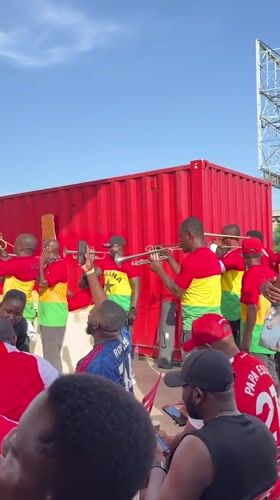 Accra crowd gathers for outdoor sports viewing with Arsenal jerseys