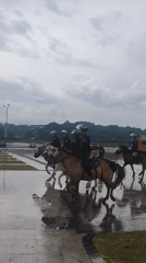 Mounted police patrol Da Lat during rainy weather