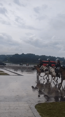 Mounted police patrol Da Lat during rainy weather