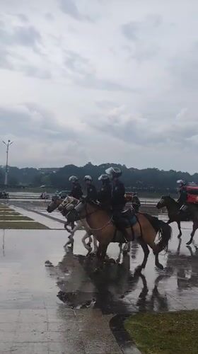 Mounted police patrol Da Lat during rainy weather