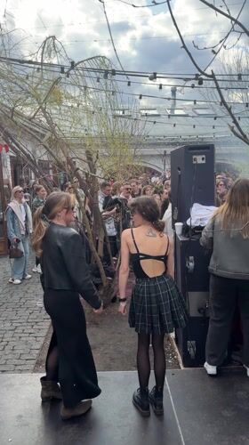 Outdoor gathering with stage performance captured in Moscow courtyard