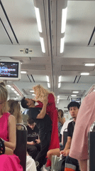 Man performs with blonde doll on Spanish train