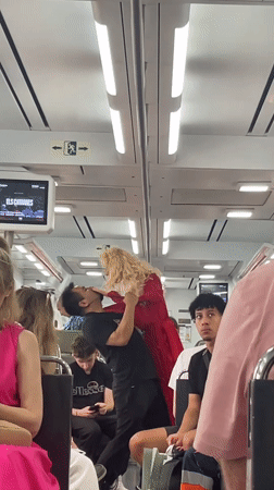 Man performs with blonde doll on Spanish train