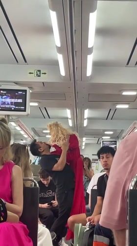 Man performs with blonde doll on Spanish train