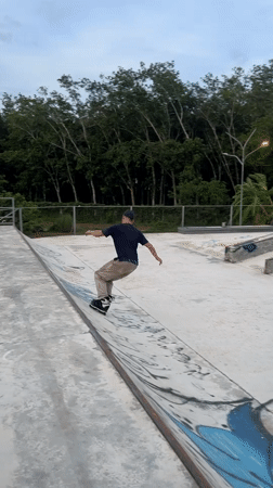 Skaters practice tricks at Thailand park with skull sculpture