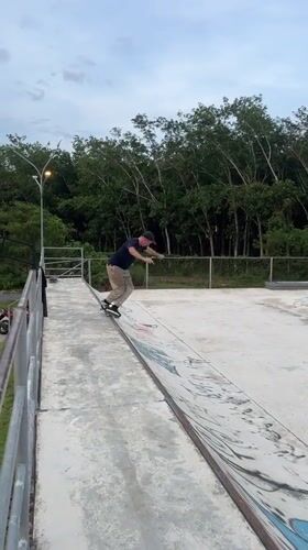 Skaters practice tricks at Thailand park with skull sculpture