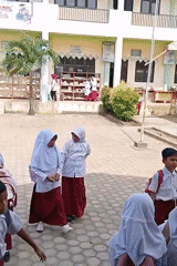 Kids in uniform gathered in a schoolyard in rural Indonesia.