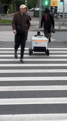 Yandex delivery robot navigates Saint Petersburg crosswalk amid pedestrians