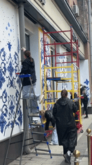 Women paint floral murals on Moscow storefronts near Planetarium