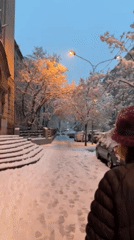 Winter pedestrian walks snowy Belgrade street during evening hours