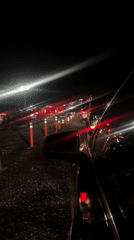 Cars queue at night in Indio with traffic control