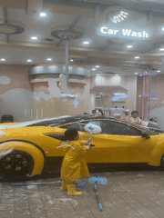 Kids scrub a foam-covered toy car at NEOBIO play center, Liangjiang