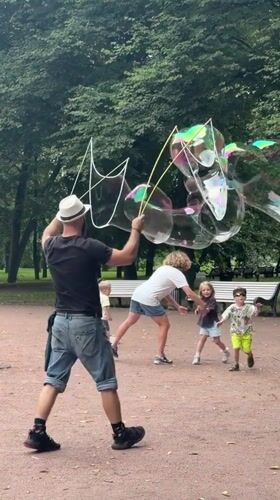 Giant iridescent bubbles drifting through a Saint Petersburg park