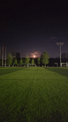 Full moon rises over a floodlit soccer field in Chongqing