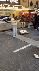 Street violinist performs near Buenos Aires theater showing Rocky musical