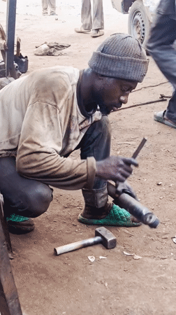 Auto mechanics work at informal roadside workshop in Nigeria