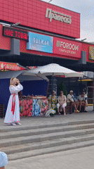 Folk performers in traditional dress sing outdoors in Svietlahorsk
