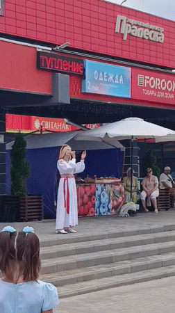 Folk performers in traditional dress sing outdoors in Svietlahorsk