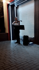 Violin performance outside a modern building in Bender, Moldova