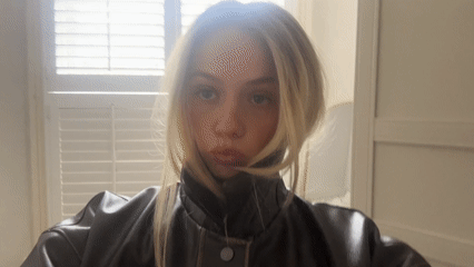 Woman takes playful selfies in black leather jacket, London