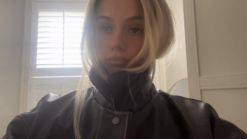 Woman takes playful selfies in black leather jacket, London