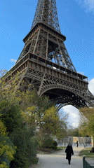 Woman walks near Eiffel Tower in Paris afternoon