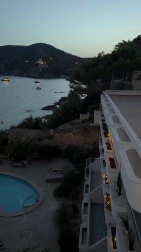 Dusk at an Andratx resort pool overlooking a boat-filled bay
