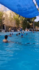 Swimmers train in a shaded outdoor lap pool in Nha Trang