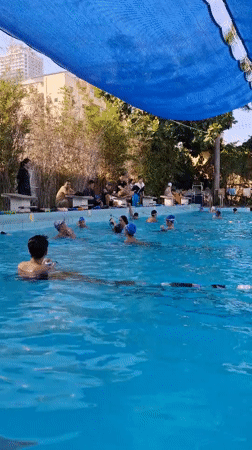 Swimmers train in a shaded outdoor lap pool in Nha Trang