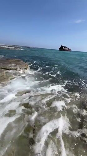 Rusted shipwreck off Akrotiri's rocky shore, Cyprus