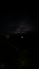 Lightning storm moves over a darkened cityscape at night