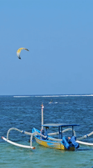 Colorful Jukung boats and water sports on a Denpasar beach