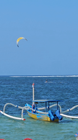 Colorful Jukung boats and water sports on a Denpasar beach
