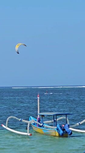Colorful Jukung boats and water sports on a Denpasar beach