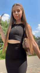 Woman photographs herself at bridge and park in Klin