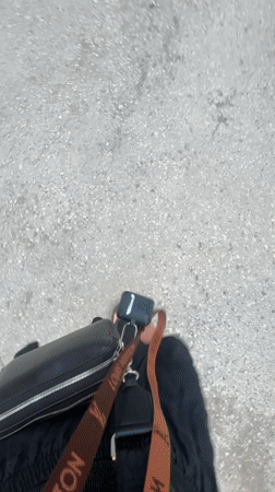 Woman walks street in Perm carrying designer purse