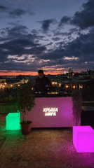 DJ sets up pink rooftop booth for nighttime performance