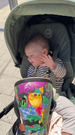 Baby plays jungle drum in stroller, Tel Aviv