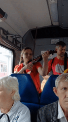 Violin playing on a Novosibirsk train, city passing outside