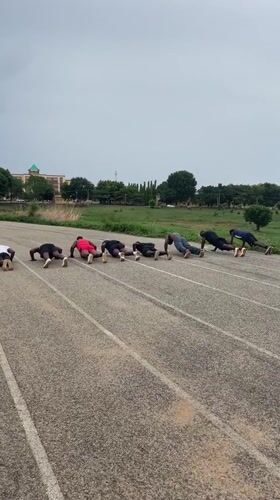 Group performs synchronized push-ups on Keffi running track