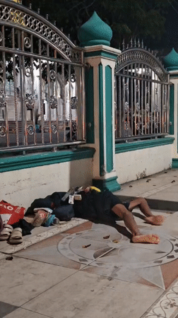 Person observed resting on sidewalk in Lhokseumawe, Indonesia