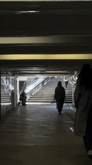 Person kneels in Moscow underground pedestrian tunnel