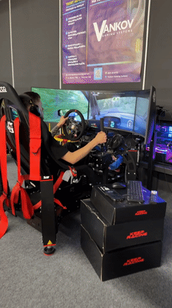 Man plays racing simulator at trade show in Bulgaria