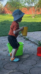 Toddler plays with toys on patio in rural Russia