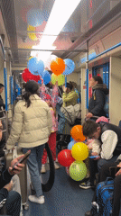 Balloons fill a Moscow metro car on an ordinary commute