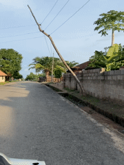 Vehicle travels worn paved road in Mararaba, Nigeria